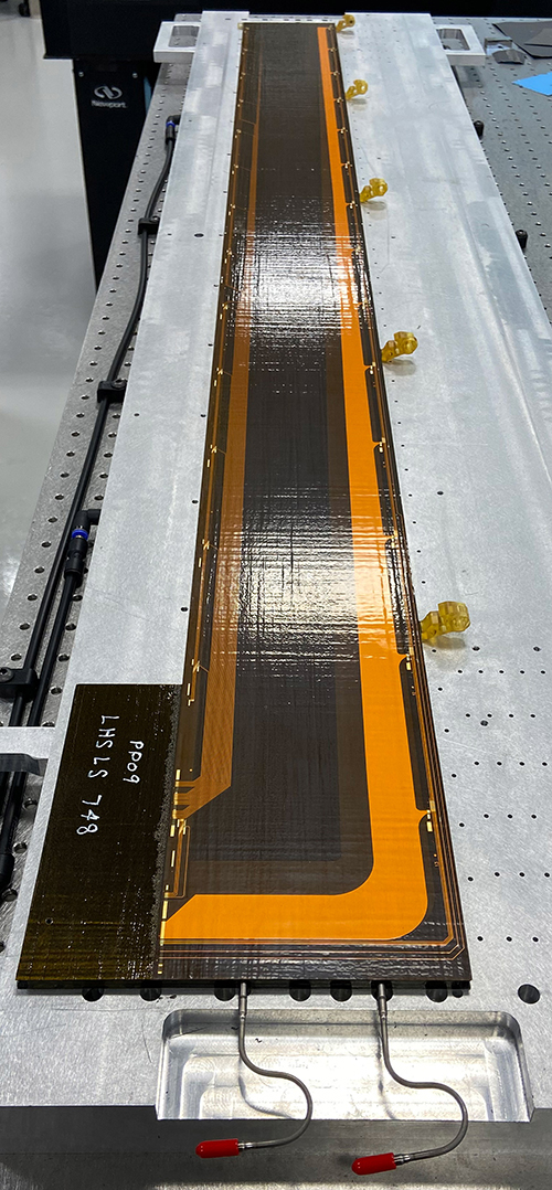 A stave after the full lamination process is completed, and visible now is the topside bus tape, a printed circuit consisting of two layers of etched copper and Kapton polyimide insulation. Photo credit: Jeffrey Ashenfelder, Yale University
