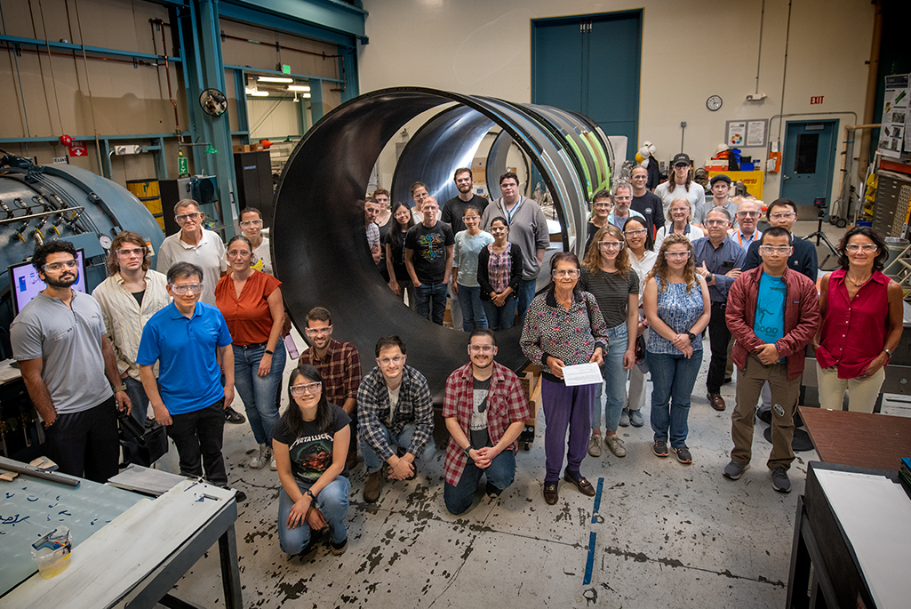 Photo caption: Member of the ATLAS team with the outer cylinder at Berkeley Lab. Credit: Thor Swift, Berkeley Lab
