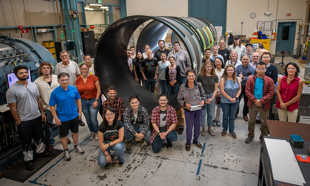 Berkeley Lab's ATLAS research group poses next to the outer barrel shell. Credit: Thor Swift, November 2023.