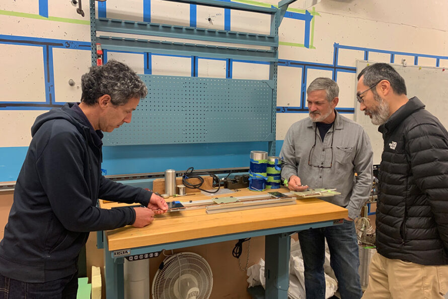 Paolo Ferracin, senior scientist and deputy of ATAP’s Superconducting Magnet Program, Hugh Higley, contractor to the program, and Xiaorong Wang, a staff scientist at SMP, analyze a sample of 6-around-1 superconducting REBCO cable. Michele Pixa/Berkeley Lab