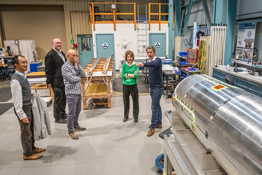 To close the day, Gianotti (center, in bright green sweater) toured Berkeley Lab’s superconducting magnet facilities with (from left to right) Ian Pong (ATAP staff scientist), Cameron Geddes (ATAP Division Director), Dan Cheng (a mechanical engineer in the Lab’s Engineering Division), and Paolo Ferracin (ATAP senior scientist and deputy for the Berkeley Center for Magnet Technology). (Credit: Robinson Kuntz, Berkeley Lab)