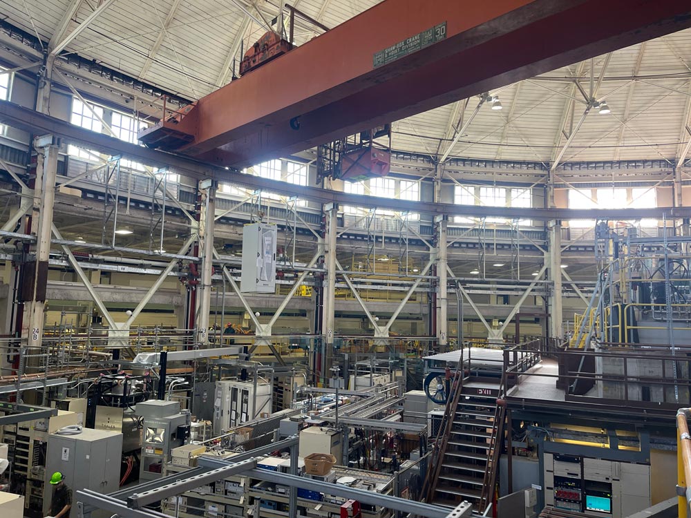A specialized ALS-U electronics rack is lifted into place during an ALS shutdown. A custom rack lift fixture, designed and fabricated by the Engineering Division at Berkeley Lab, helps the polar crane attach to the rack, creating a slimmer overall profile during crane lifts. This allows racks to be easily lifted over obstructions and makes the process more efficient for the crew. Credit: Kyle McCombs, Berkeley Lab