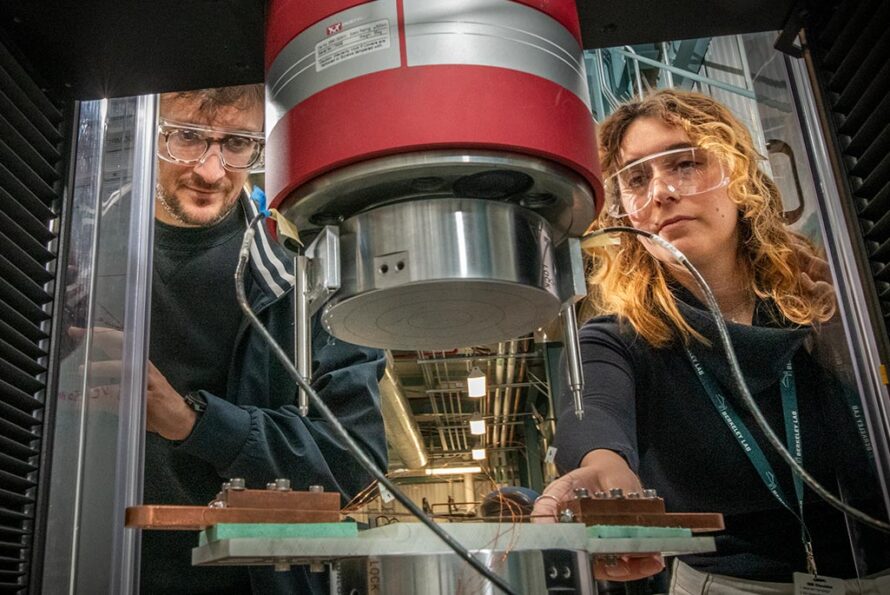 Caption: Giorgio Vallone (left) and Marika D’Addazio test components for a superconducting magnet at Berkeley Lab. Credit: Robinson Kuntz/Berkeley Lab Alt text: Two researchers in protective glasses look into a superconducting magnet experimental setup.