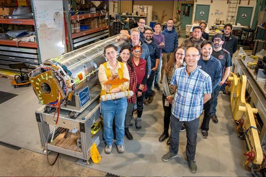 Berkeley Lab staff stand next to the final magnet for the high luminosity upgrade to the Large Hadron Collider. (Credit: Robinson Kuntz/Berkeley Lab)