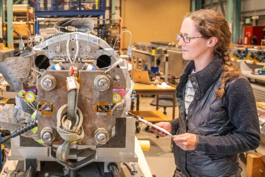 Jennifer Doyle with a magnet for the High-Luminosity Large Hadron Collider Accelerator Upgrade Project. (Credit: Robinson Kuntz, Berkeley Lab)