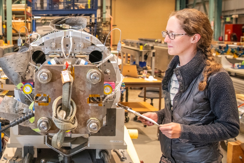 Jennifer Doyle with a magnet for the High-Luminosity Large Hadron Collider Accelerator Upgrade Project. (Credit: Robinson Kuntz, Berkeley Lab)