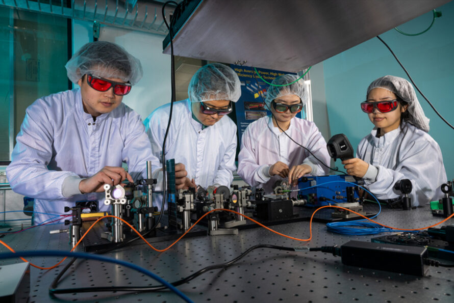 Tong Zhou, Qiang Du, Siyun Chen, and Dan Wang work on the spectral combining of multiple fiber lasers in the fiber laser lab. (Credit: Paul Mueller, Berkeley Lab)