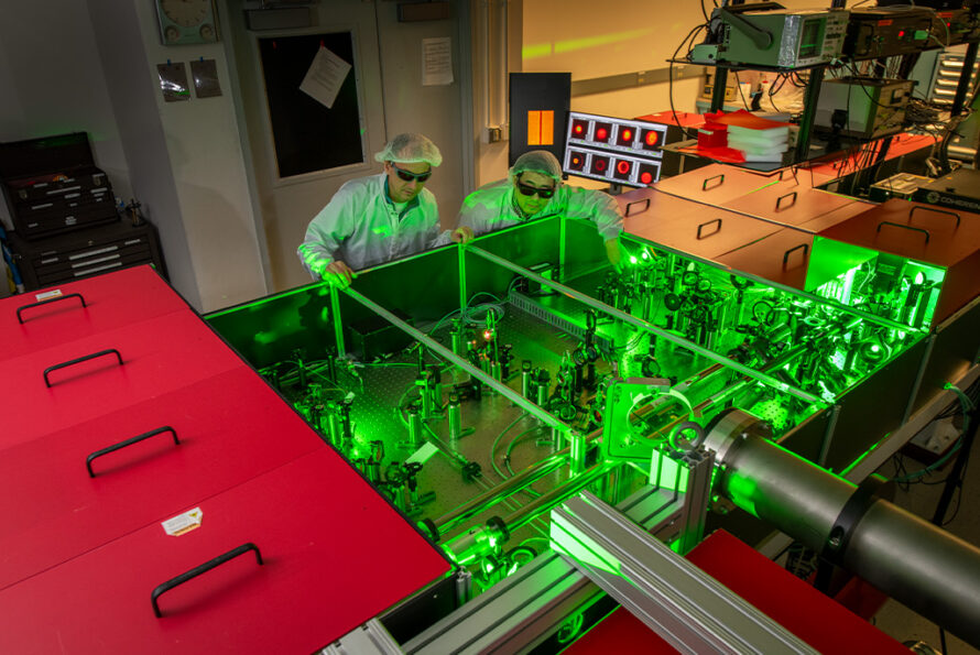 Jeroen van Tilborg and Hai-En Tsai inspect the optical table that houses the high-power laser amplifier at Berkeley Lab's BELLA Center. (Credit: Credit: Robinson Kuntz, Berkeley Lab)