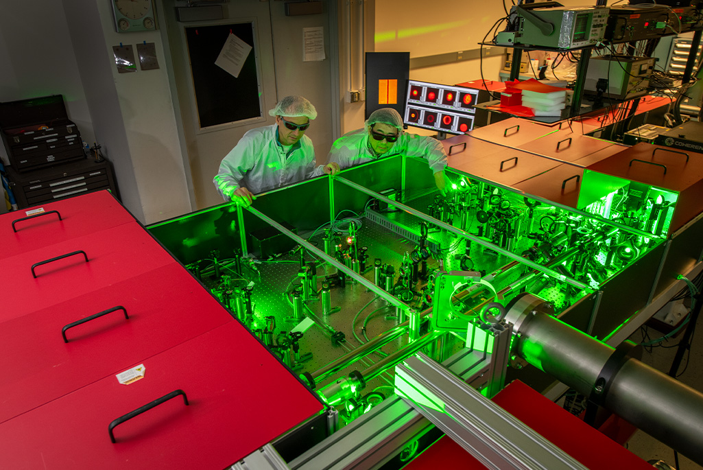 Jeroen van Tilborg and Hai-En Tsai inspect the optical table that houses the high-power laser amplifier at Berkeley Lab's BELLA Center. (Credit: Credit: Robinson Kuntz, Berkeley Lab)